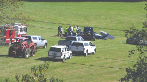 Shelby Powell/CNI News Service. Emergency personnel respond to a plane crash Thursday afternoon in a field west of Iotla Valley Elementary School. The three people aboard were killed.
