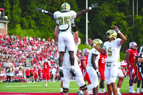 Wesley Branch/The Clayton Tribune. Rabun Gap offensive lineman Wilson Zierer lifts running back Jordan Lindo into the air in celebration after a 5-yard touchdown against Baylor on Aug. 29. The Eagles earned their first win of the season the next week at Massillon Washington High School, 50-35.