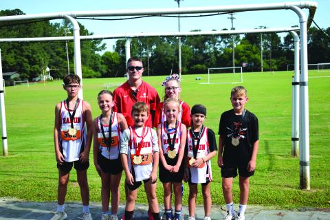 Submitted Photo. Top 10 finishers pictured along with Head Coach Ed Eidson, include Caiden Wood, Harper Westbrook, Owen Moseley, Madison Anderson, Opal Aker, Nora Webb, and Keegan Hanifan-Wagner.