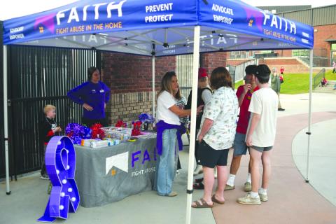 Enoch Autry/The Clayton Tribune. Members of F.A.I.T.H. had a tent at the Oct. 3 football game between Rabun County and Commerce to provide people with information about awareness for domestic violence and dating violence.