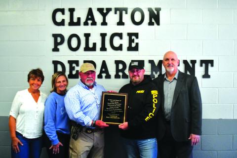 Enoch Autry/The Clayton Tribune. Tracy Crunkleton Wilson, Trudy Crunkleton, Rabun County Sheriff Mark Gerrells, Clayton Police Chief Andy Strait and Clayton Mayor pose with the plaque to honor John Burton, the Clayton police chief who was fatally shot 100 years ago. Wilson and Crunkleton, the current Clayton city manager, are the great granddaughters of Burton. Gerrells, who researched how to get Burton honored, is a former Clayton police chief.