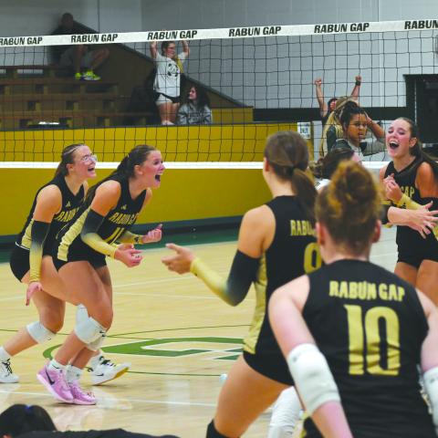 Wesley Branch/The Clayton Tribune. Rabun Gap volleyball players celebrate after the game-winning point versus Tallulah Falls School on Aug. 19. The Eagles’ 14 regular season wins are already more than the team had last season. 