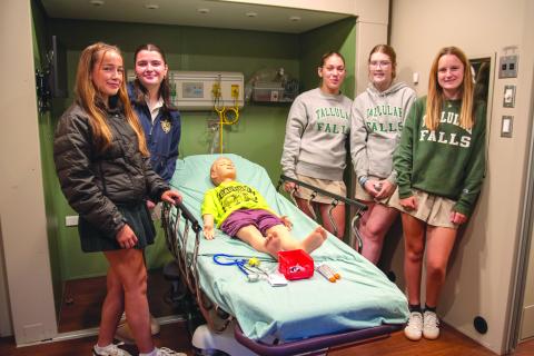 Submitted Photo. TFS juniors Haylen McGugan of Clarkesville, Callee Elrod of Clermont, Sophie Smith of Clarkesville, Shelby Whisnant of Toccoa, and Reagan Duff of Clermont practice using an EPIPen in the simulation lab. 