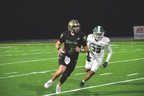 Wesley Branch/The Clayton Tribune. Rabun Gap quarterback Grayson Clary looks downfield for a receiver while escaping a Christ School defender in the Eagles’ 64-7 win over the Greenies on Nov. 6. Clary threw for two touchdowns in the game. 