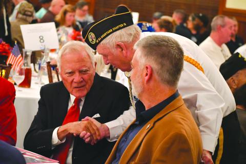 Enoch Autry/The Clayton Tribune. Doug Wayne of the Northeast Georgia Mountains Chapter 15 of Disabled American Veterans shakes the hand of former Georgia Gov. Nathan Deal at the 26th annual Veterans Appreciation Dinner at The Dillard House Resort. In the foreground is State Rep. Victor Anderson.