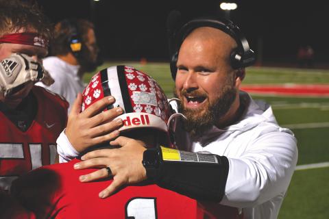 Wesley Branch/The Clayton Tribune. Rabun County running backs coach Clay Worley hugs Lake Evans after the senior dashes down the visitors’ sideline for a 46-yard touchdown on Nov. 21. The Wildcats head to Pepperell for the Elite Eight Friday.