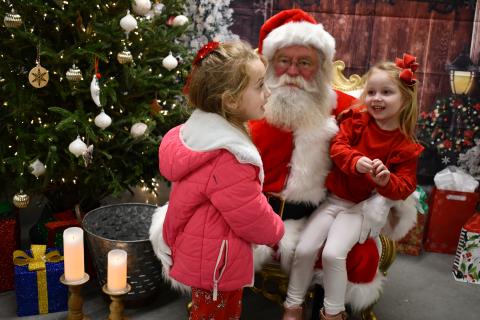 Megan Horn/The Clayton Tribune. Lyla Messer, 6; and Gentry Messer, 4, happily visit Santa “On the Farm” and tell him what they want for Christmas, during the Dec. 4 event hosted by the RCHS and RCMS FFA chapters. 
