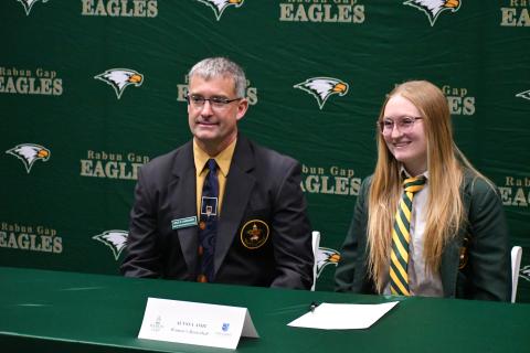 Wesley Branch/The Clayton Tribune. Rabun Gap-Nacoochee School athletic director and girls basketball head coach Dale Earnhardt (left) and Alyssa Ashe pose for a photo during Rabun Gap’s signing day festivities on Dec. 3. Ashe will be continuing her athletic and academic careers at Covenant College