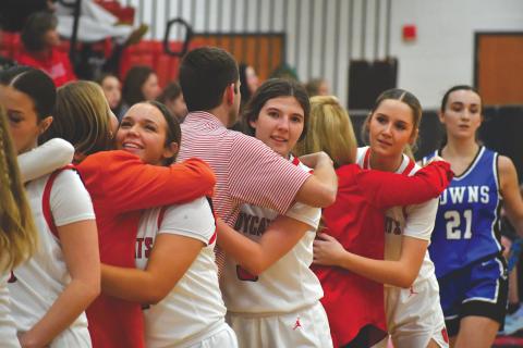 Wesley Branch/The Clayton Tribune. Rabun County seniors hug head coach DeeDee Dillard and assistant coaches Bryce Dillard and Makenna Talcott as they come off the floor in Lady Cats’ 70-16 win over Towns County on Senior Night on Dec. 9.  