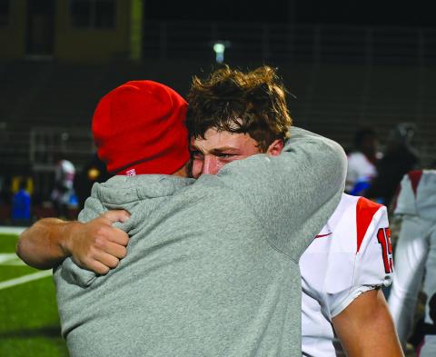Enoch Autry/The Clayton Tribune. Rabun County senior Reid Giles sheds a tear during a hug with assistant coach Clay Worley on the field after the Wildcats lose to Pepperell in the Elite Eight in Lindale the day after Thanksgiving.