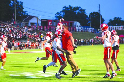 Wesley Branch/The Clayton Tribune.  Rabun County junior linebacker JK Fruster celebrates with assistant coach Ty Maxwell after the Rabun County defense forces a turnover in the Wildcats’ 49-42 road win over Dalton on Sept. 5, 2025.  