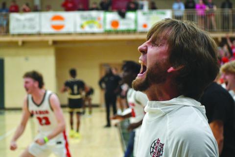 Wesley Branch/The Clayton Tribune. Rabun County Wildcat head coach David Adcock yells in celebration as the buzzer sounds in Rabun County's 58-53 overtime win over Commerce on Feb. 20 at Piedmont University to claim the region tournament championship. The win gave Rabun County back-to-back region titles for the first time in program history. RCHS also defeated Chattooga in the first round of the state tourney on Tuesday. 