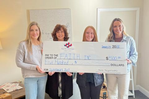 Submitted photo. North Georgia Credit Union sponsors F.A.I.T.H. Sweetheart Ball. Pictured are Kelsey Taylor, F.A.I.T.H. director of outreach services; Carrie Kuehne, Clayton assistant branch manager; Katie Fowler, member service representative and Brooke Cannon, F.A.I.T.H. CFO, displaying the $500 check.