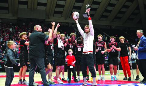 Enoch Autry/The Clayton Tribune. The Rabun County boys basketball team is the Class A Division I state champions for 2026 after capturing the title on March 13 in the Macon Coliseum with a 52-43 victory over Southwest for the first boys hoops championship in the school's history. Here Rabun County head coach David Adcock hoists the trophy and game ball into the air for his team and the crowd to see at midcourt following the triumph. 