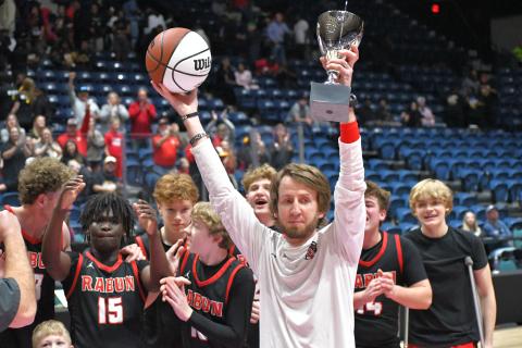 Wesley Branch/The Clayton Tribune. RCHS head coach David Adcock holds up the trophy and game ball as the Class A Division I state champions while his team celebrates the achievement.