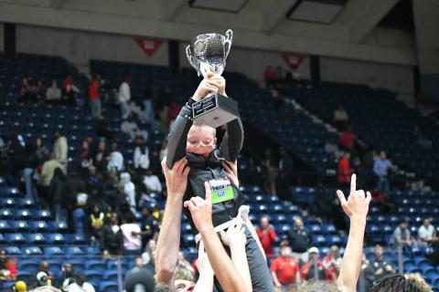 Wesley Branch/The Clayton Tribune. The Rabun County boys basketball team lifts Reeves Page, the son of assistant coach Corey Page, in celebration with the championship trophy after the team’s 52-43 state title victory over Southwest on March 13 at the Macon Coliseum. The championship is the first in the history of the boys basketball program. 