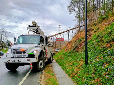 Megan Horn/The Clayton Tribune. Clayton Police Department officers and Georgia Power workers remove a tree that fell on power lines in the area of Ga. 15 at O’Reilly Auto Parts on the morning of March 12. 