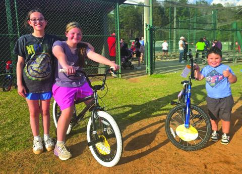 Enoch Autry/The Clayton Tribune. Winners of this year’s bicycles at the April 2 annual Rabun County Recreation Department Easter Egg Hunt are 10-year-old Maleigha Beck (sitting on bike) and Karlos Luka, 4, who is giving a hearty thumbs up. Standing next to Beck is happy friend Anna Frederickson.