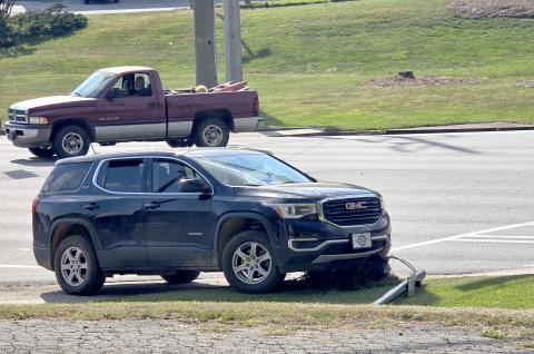 Enoch Autry/The Clayton Tribune. The vehicle that reportedly struck a U.S. 441 crosswalk sign is shown on top of the knocked down pole at the crash scene on April 23.