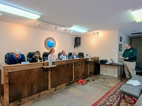 Megan Horn/The Clayton Tribune. Sky Valley City Manager Jason Streetman, far right, reads aloud two city resolutions to rescind combined $5 million from two separate grants during the March 26 special called council meeting.