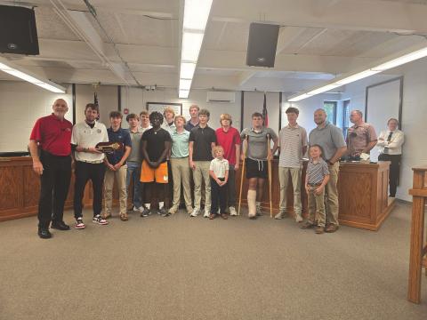Enoch Autry/The Clayton Tribune. Clayton Mayor Roy Quilliams presents Rabun County head boys basketball coach David Adcock (far left) with a key to the city as the Wildcats stand in the front of the meeting room in city hall on May 12.