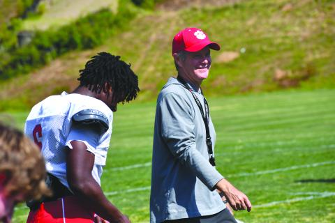 Wesley Branch/The Clayton Tribune. Rabun County High School head football coach Rance Gillespie smiles while chatting with rising senior linebacker JK Fruster during the Wildcats’ spring football practice on May 5. Gillespie is entering his second season as the head coach of RCHS, where he played in the 1980s.  