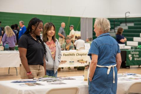 Photo courtesy Elisha Boggs.  TFS students Kaylin Pickett and Jessica Cook visit with the exhibitor at the Rabun County, Georgia Extension Office, where they picked up wildflower seeds to plant at home. 