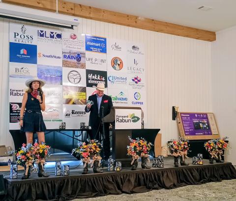 Megan Horn/The Clayton Tribune. Brenda Patterson, owner of White Birch Inn, White Birch Provisions and The Watchmaker’s Workspace, received the 2026 Entrepreneur of the Year award. Patterson thanked the community for their support. She stands on stage with Forward Rabun President Rick Story. 
