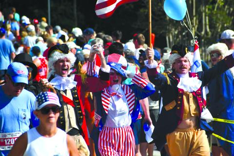 Wesley Branch/The Clayton Tribune. Several participants of the Lake Burton Fun Run showed their patriotism by wearing red, white and blue, or by dressing up in costumes like the trio celebrating here as they cross the finish line. Despite the warm temperatures, thousands were in attendance on July 4 for the 42nd annual Lake Burton Fun Run from Moccasin Creek State Park to LaPrade’s Marina. 