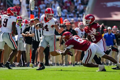 Tony Walsh/UGAAA. Former Rabun County and current Georgia quarterback Gunner Stockton (center) fights off Arkansas defenders during Georgia’s 45-17 win over Arkansas on Sept. 19. Stockton threw for 147 yards and a touchdown, and ran for 97 yards in the win.
