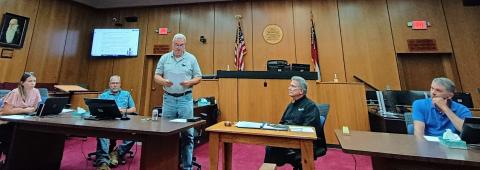 Megan Horn/The Clayton Tribune. Commissioner Kent Woerner reads aloud a proclamation supporting Rabun County Search and Rescue (SAR).