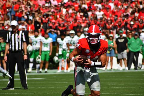 Wesley Branch/The Clayton Tribune. In his first regular-season game as a starter, Bulldog quarterback Gunner Stockton of Tiger pulls the ball down on a scramble against visiting Marshall on Aug. 30, 2025. Georgia opens its 2026 season again at home as Tennessee State comes to Athens.