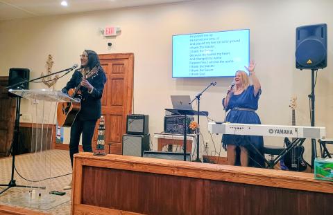 Megan Horn/The Clayton Tribune. Debbie Peack-Catrina, left playing the guitar, and Angel McCuen praise Jesus and lead worship music in the sanctuary at the 10-year celebration of Freedom Ministries Lighthouse on Saturday, Sept. 12. 