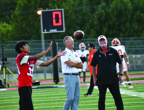 Enoch Autry/The Clayton Tribune. With Wildcat Yiar Avila catching a football in front of them, Rabun County head coach Rance Gillespie (left) talks with former RCHS head coach and current Metter head coach Lee Shaw prior to the Aug. 28 matchup between the two teams in Tiger. RCHS won the back-and-forth contest 27-23 to begin 1-0.