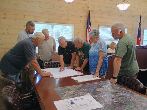 Megan Horn/The Clayton Tribune. Lead Pastor of River Point Rabun Community Church, other church officials and Tiger Town Council members look at preliminary site plans for a new church building to potentially be built in city limits during the Aug. 10 council meeting. 