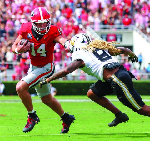 Landen Todd/CNI News Service. Georgia quarterback and Tiger resident Gunner Stockton stiffarms Vandy’s CJ Heard as the senior rushed seven times for 22 yards in Georgia’s SEC win. No. 2-ranked UGA faces No. 6 Alabama on Saturday.