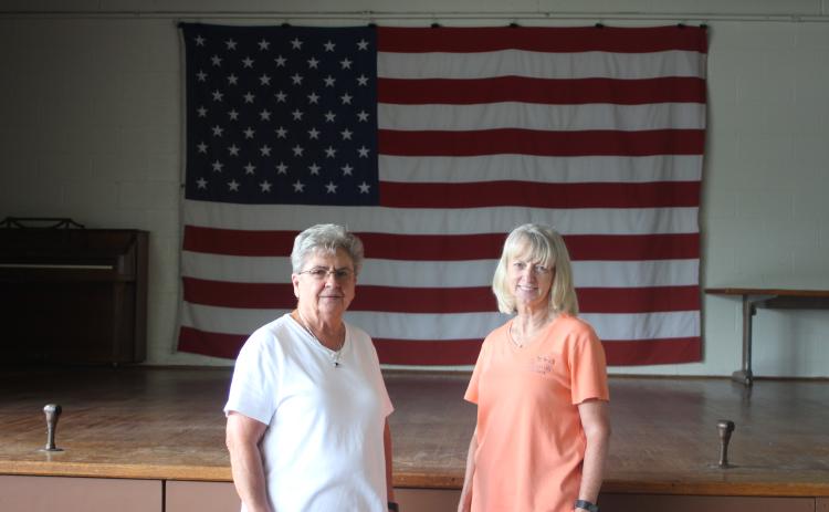 Grace Watts, mayor of Mountain City, left, and Brenda Cannon, city clerk, stand in front of the stage on new flooring at Mountain City's city hall where the Bicentennial square dance will take place on Saturday, July 20