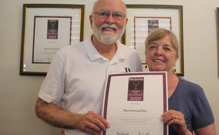 Megan Broome/The Clayton Tribune. David Darugh, left, and Gayle Darugh, hold up their award for having Beechwood Inn honored for its wine program with the Wine Spectator Restaurant Award of Excellence for 2019. They have been a consecutive winner of the award since 2007.