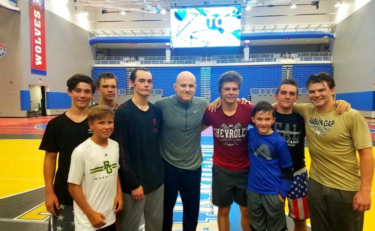 Nolan Conrad of Clayton, Charlie Hall of Long Creek, S.C., Aiden McMullen of Highlands, N.C., Cole Owens of Conyers, Cael Sanderson (Penn State coach), Aidan Loring of Clayton, Brody Fon of Franklin, N.C., Matt Campbell of Highlands, N.C., and Quill Martin of Clayton are pictured. (Photo courtesy of Rabun Gap-Nacoochee School)