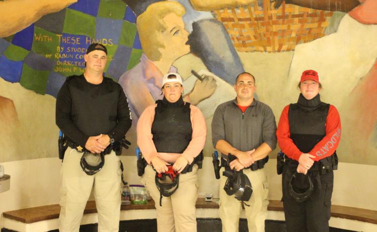 Megan Broome/The Clayton Tribune. Rabun County School Resource Officers (SROs) Sgt. Tim Brown, Deputy Beth Darnell, Deputy Chris Bartolomey and Deputy Lisa Thompson don their protective gear to train in the Heightened Emergency Response Officer (HERO) program at Rabun County Middle School on July 31 in preparation for the new school year. Lt. Mark Gerrells from the Rabun County Sheriff’s Office trains the SROs on this program.