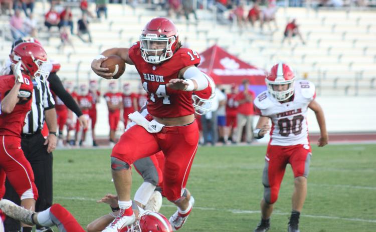 Rabun County quarterback Gunner Stockton (14) leaps a fallen Franklin (N.C.) player during a touchdown run in the second quarter of a preseason game at Frank Snyder Memorial Stadium in Tiger last Friday night. (Glendon Poe/The Clayton Tribune)