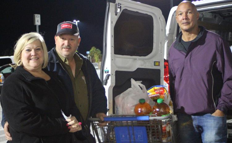 Megan Broome/The Clayton Tribune. Lori Hunter, left, Jeff Hunter of Hunter Electric with Food Bank Manager James Brim.