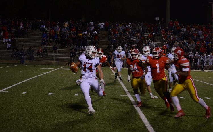 Rabun County quarterback Gunner Stockton (14) tries to avoid oncoming Thomasville defenders Friday night.