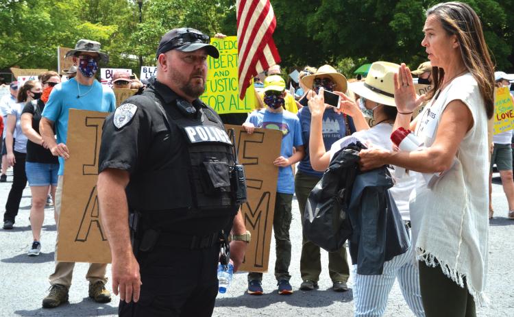 Wayne Knuckles/The Clayton Tribune. Clayton Police Chief Andy Strait, left, talks with vigil organizer Sarah Gillespie before the start of Saturday's Silent March.