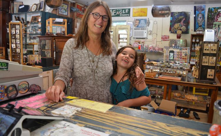 Wayne Knuckles/The Clayton Tribune. Mary Beth Hughes and granddaughter Leena Bundrick at the counter of Tallulah Point Overlook Store Monday. The longtime tourist attraction is relocating at the end of July.