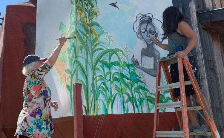 Daniela Cintron/The Clayton Tribune. Lizzy Falcón, right, paints with Diane Rush on one of the spaces outside the new The Lotus Gallery and Art Center, which plans to officially open its doors in 2021 to incite art with local and worldwide artists.