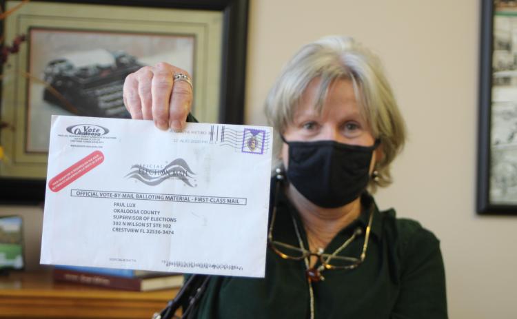 Megan Broome/The Clayton Tribune. Voter Pamela Wawrzyk holds up an absentee ballot that was returned by the post office for an unknown reason. She said that she and her husband Stephen found the ballot in their mailbox when they came back from Florida and it had no indication of the reason it was returned. She cautioned voters to be sure and check their ballot status to make sure their ballot is received by the elections office for their vote to be counted.