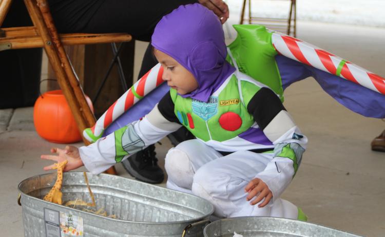 Megan Broome/The Clayton Tribune. Daniel Contreras dresses as Buzz Lightyear and plays one of the games at the Fall jamboree in Clayton Halloween night.