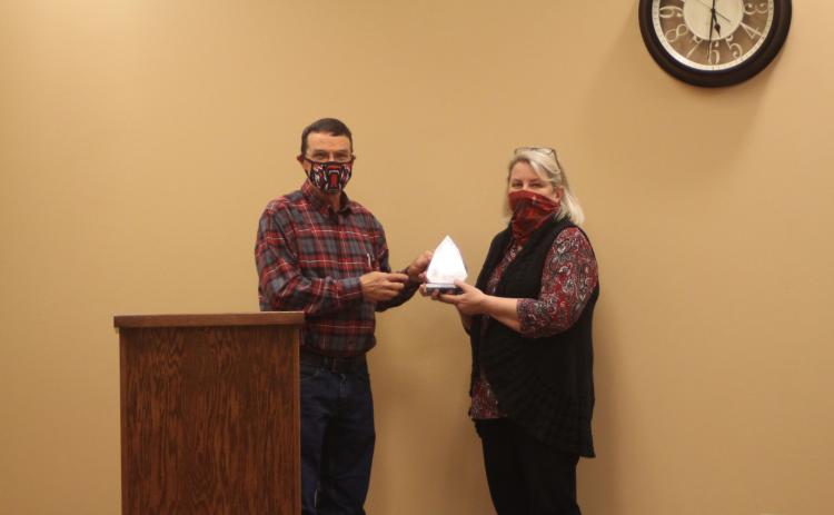 Megan Broome/The Clayton Tribune. Board of Education Chairman Steve Cabe, left, presents an award to Tax Commissioner Sandy Smith at last Thursday’s meeting. The award was presented on behalf of Board of Education members to thank Smith for her hard work during her career.  Her department’s tax collections contribute to the amount of funding Rabun County Schools receives, Superintendent April Childers explained. Smith is retiring at the end of the year.