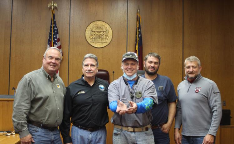 Megan Broome/The Clayton Tribune. Commissioners Kent Woerner, left, chairman Gregg James, Will Nichols, and County Administrator Darrin Giles present Stephen Arbitter (center) with an award for his 8 years of service as a commissioner at last Tuesday’s meeting. It was Arbitter’s last meeting before vacating his seat.